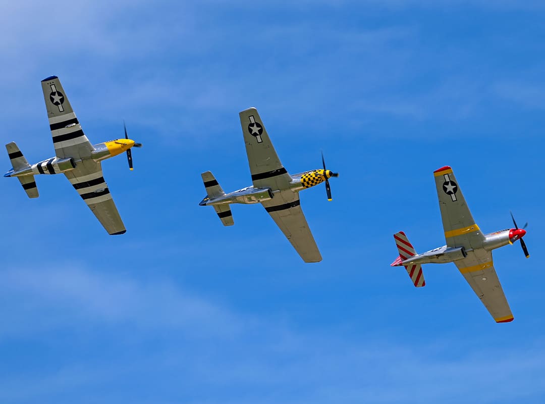 Three Jack Aces P-51 Mustang aircraft -“Mad Max,” “The Little Witch,” and “Cheryl Lynn” - flying in formation during.