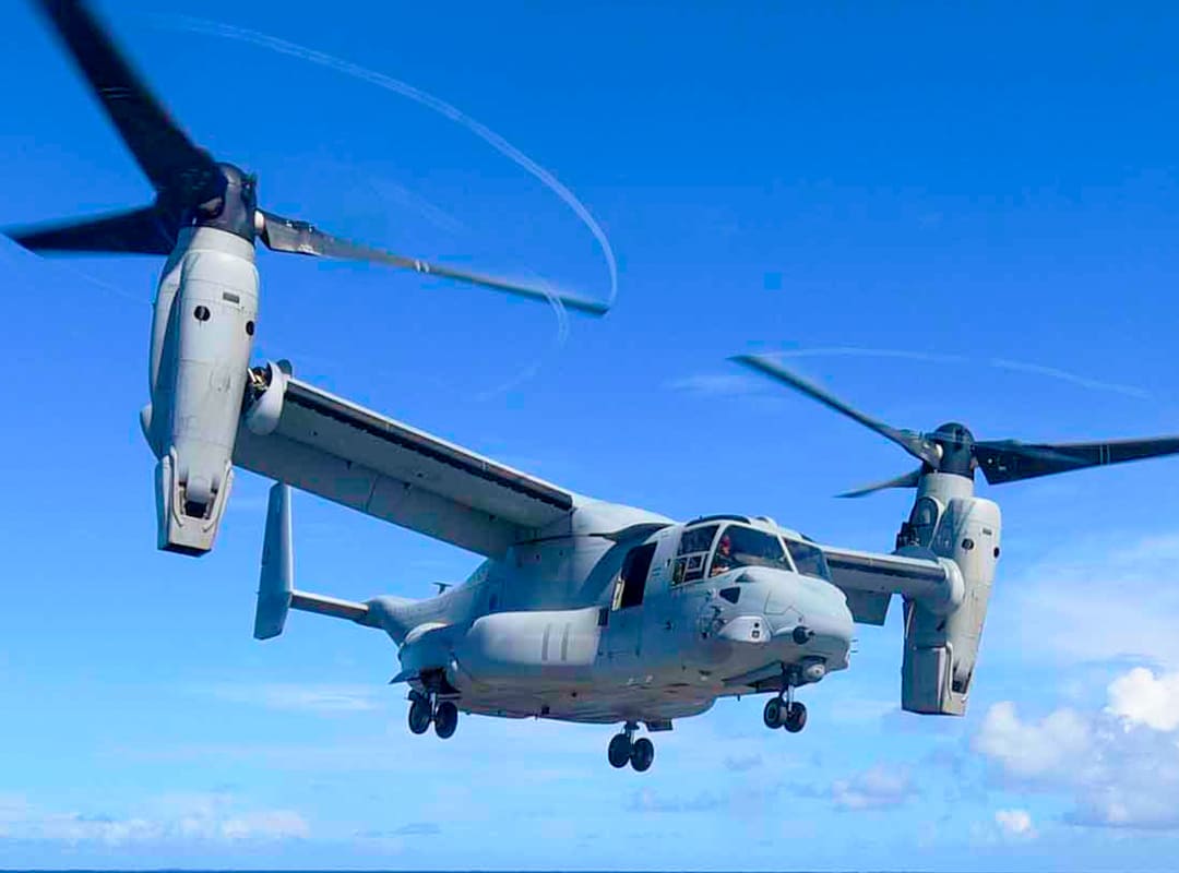 U.S. Marine Corps MV-22 Osprey tiltrotor aircraft flying with rotors in vertical (hover) position.